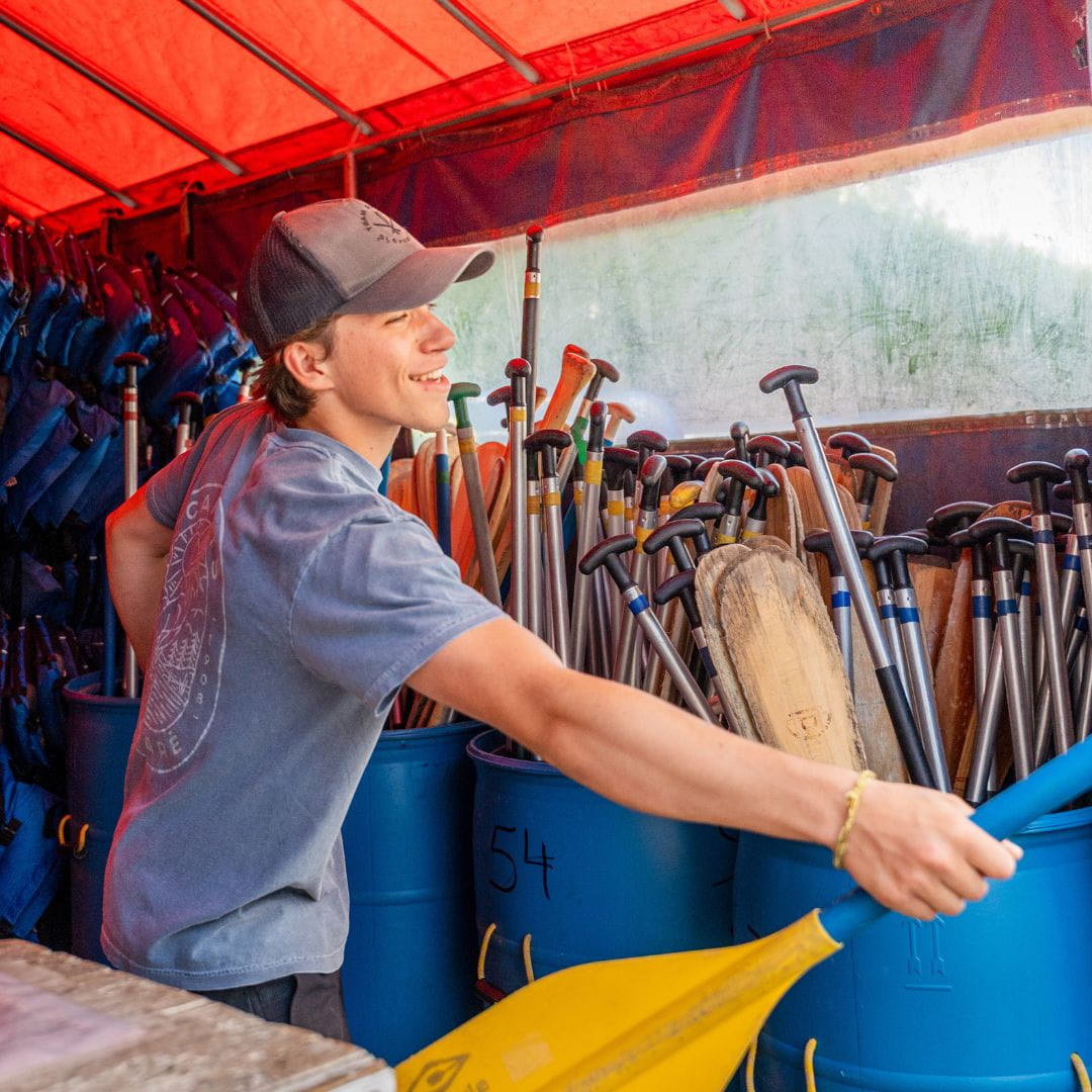 Employé souriant donnant de l'équipement de location chez Canots Légaré