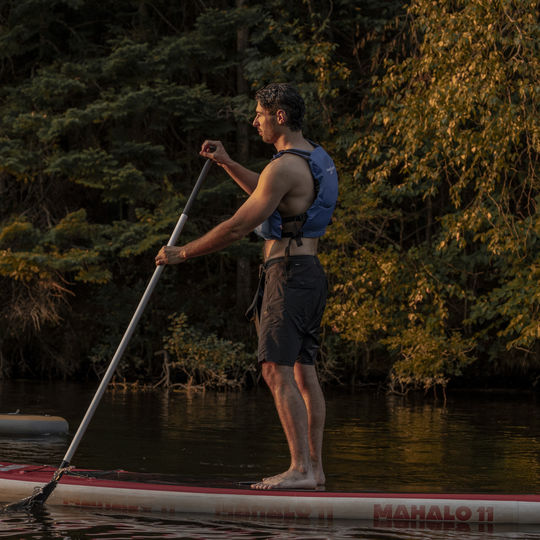 Pagayeur solo sur planche à pagaie en soirée
